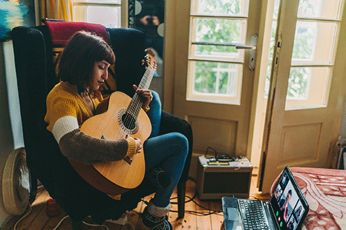 woman playing guitar at home
